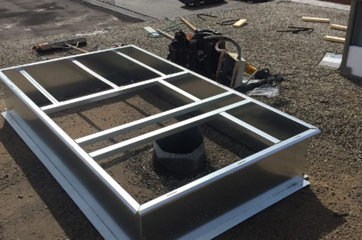 Rooftop HVAC curb being set on a commercial building