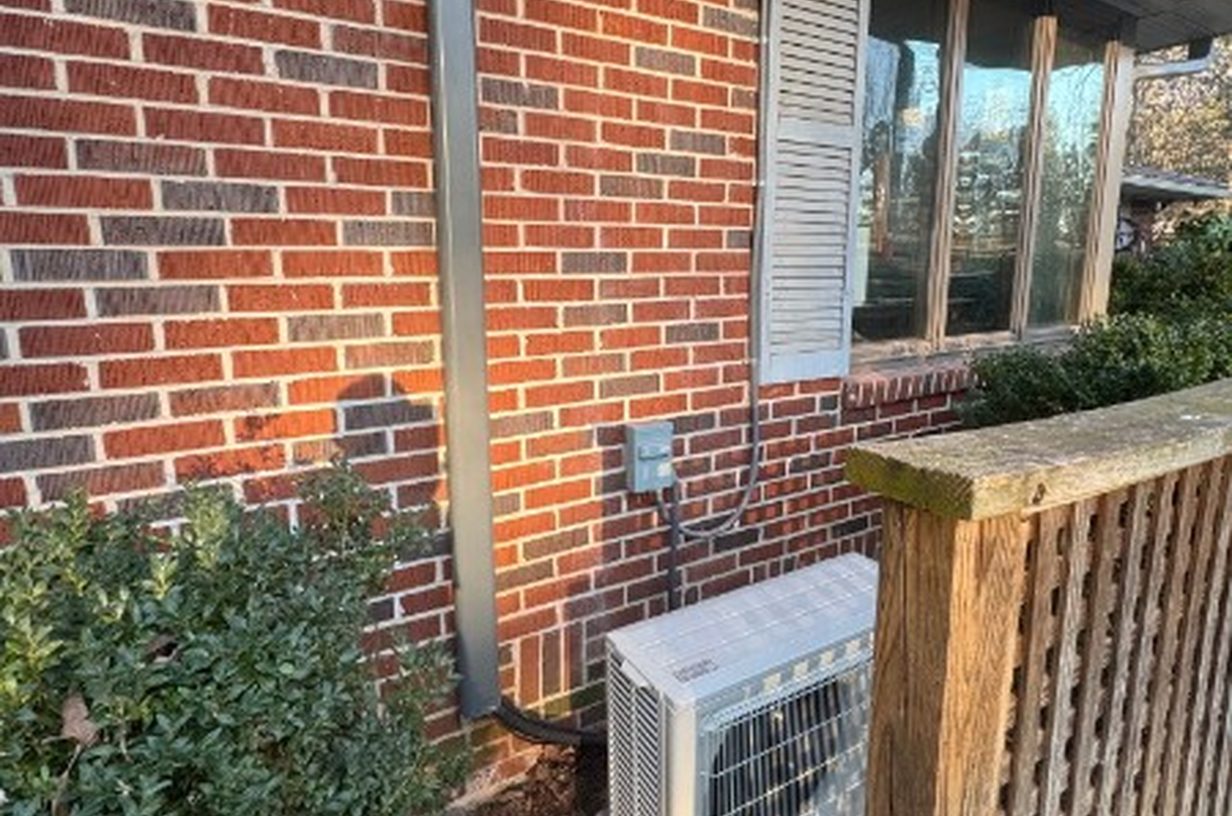 Outdoor condenser and line-set cover installed on a brick house